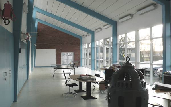 En sal med ett bord och en stol samt stora fönster i Slottshagens reningsverk.