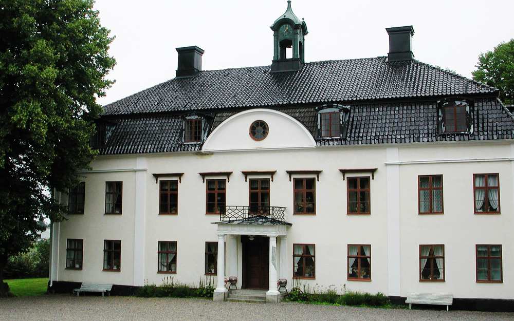 Vitt stort hus vid Broxvik med många kupade fönster