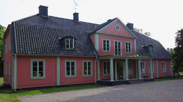 Rött hus med gräsmatta runtomkring vid Gerstaberg.