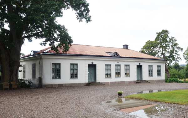 Litet vitt stenhus med grus framför Sonstorp herrgård och bruk.