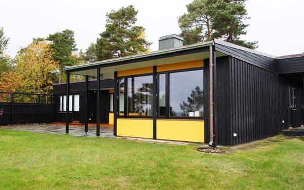 Ett hus i Arkösund med stora kvadratiska fönster och gula partier under fönsterna.