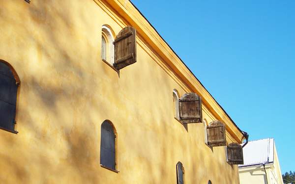 Blomkvistska huset med gul fasad mot en blå himmel.