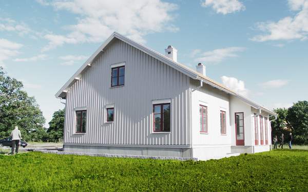 Ett vitt hus i Lindköping med röda detaljer och en grön gräsmatta runtom.