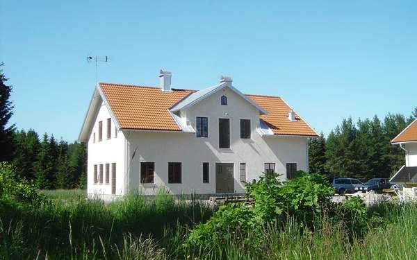 En vit stenvilla i Vikingstad med orange tak.
