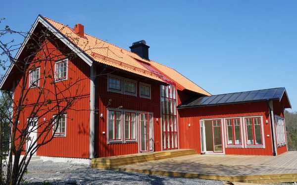 Äldre rött hus i Valdemarsvik med vita knutar.
