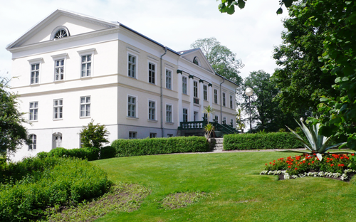 En vit synagoga med träd framför.