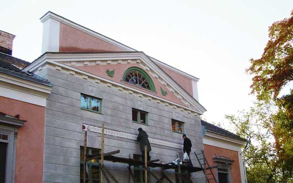 Tegelbyggnad med rosa och gröna detaljer i Hulta säteri.