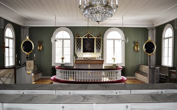 Rejmyre kyrka med vitt trätak och grönmålade träpanelväggar.