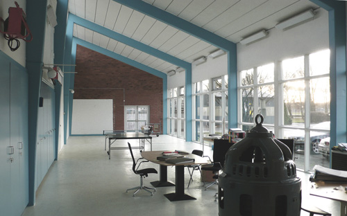 Kontorslokal på Slottshagens reningsverk med högt i tak och vita väggar, blå balkar och blå skåp.