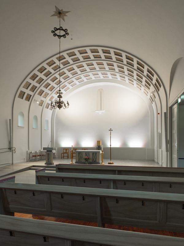 Kyrkoaltaret i Katolska kyrkan Motala med kupat tak och stolar, ljusstakar.