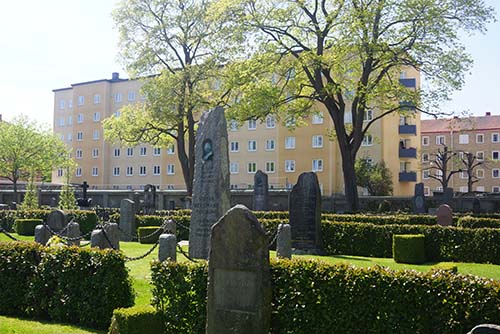 Kyrkogård med gravstenar i solljus i Norrköping.
