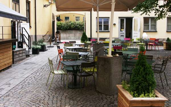 Knäppingsborgs utomhusmiljö med färgglada stolar.