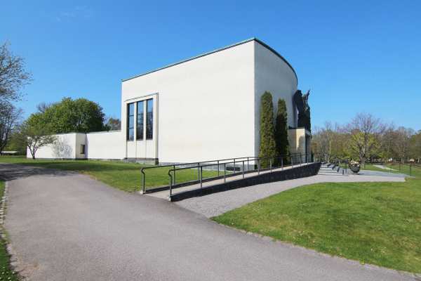 Vit byggnad rundad omgiven av grönt gräs, i Krematoriet Norrköping.