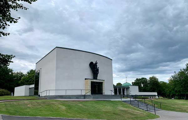 Vit byggnad rundad omgiven av grönt gräs, i Krematoriet Norrköping.