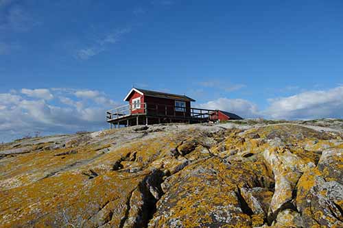 Liten röd stuga i anslutning till Måseskärs fyr.