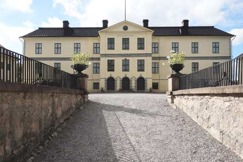 Löfstad slott i beige färg och många fönster.