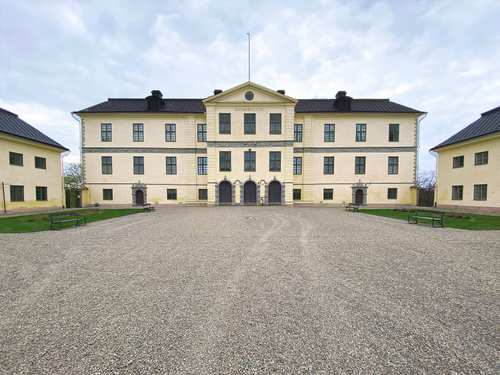 Löfstad slott i beige färg och många fönster.