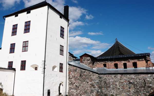 Stenhus framför tegelbyggnad i Nyköpingshus.
