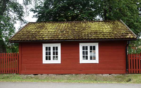 Rött hus på Östrabo med fönster med vita karmar