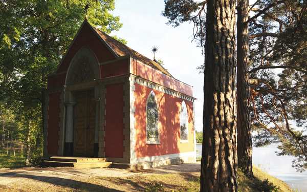 Liten rosa kyrka i skog i Rydboholm.