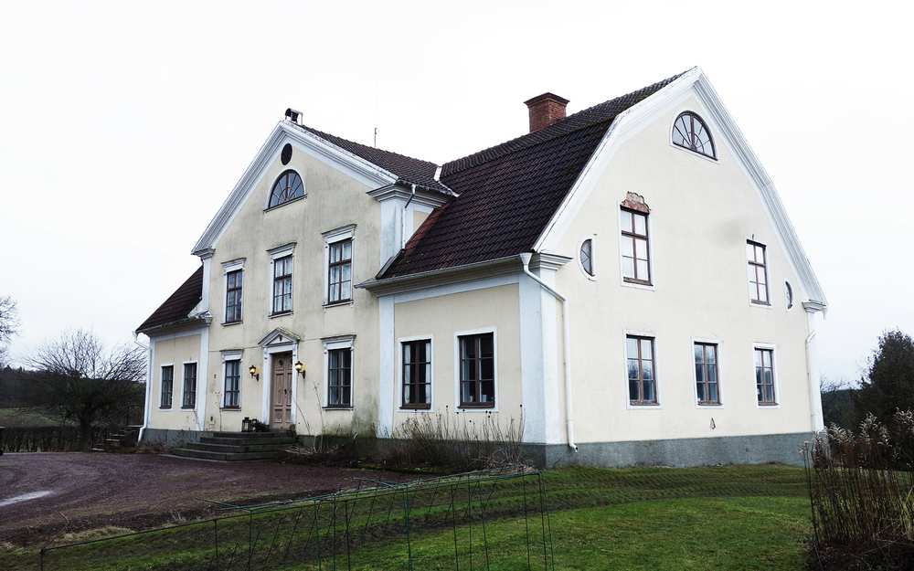 Vitt sten hus på Stjärnevik med vita ramar och detaljer.