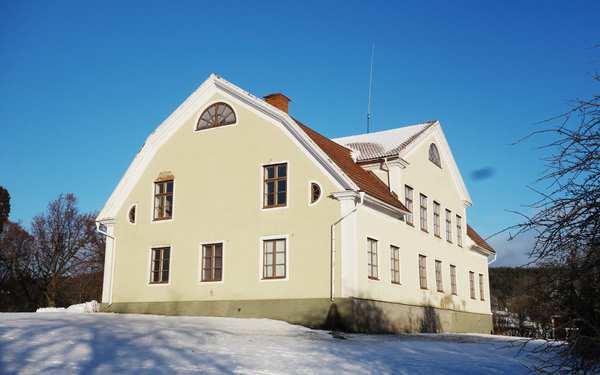 Gult och vitt hus på Stjärnevik med mörkt tak.