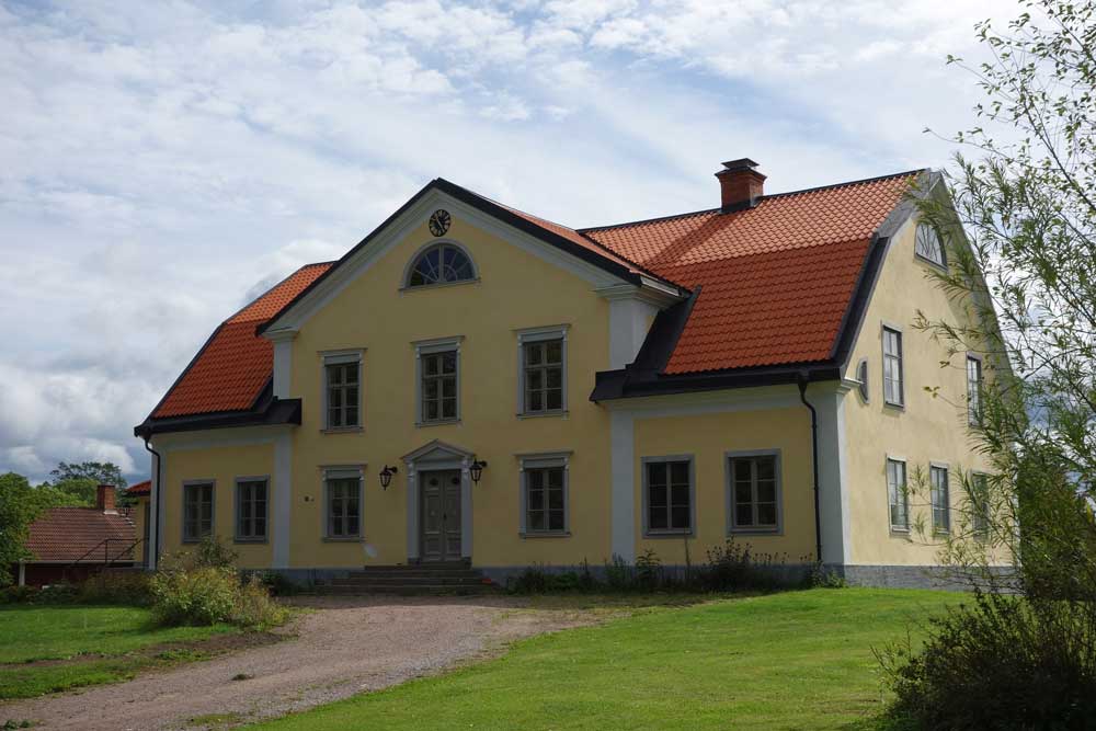 Vitt sten hus på Stjärnevik med vita ramar och detaljer.