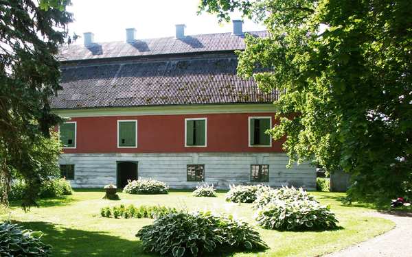 Byggnad i rött och vitt vid Tuna kungsgård.