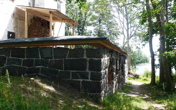 Stenmur i svart med ett tak på Vinäs slottsruin