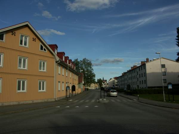 Trähus längs en väg vid Gamla Brandstationen, gula och turkosa.