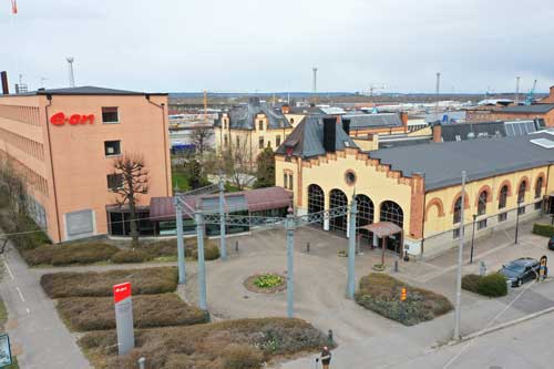Triangeln Södra Hamnen med en tegelbyggnad bredvid som har EONs skylt på sig.